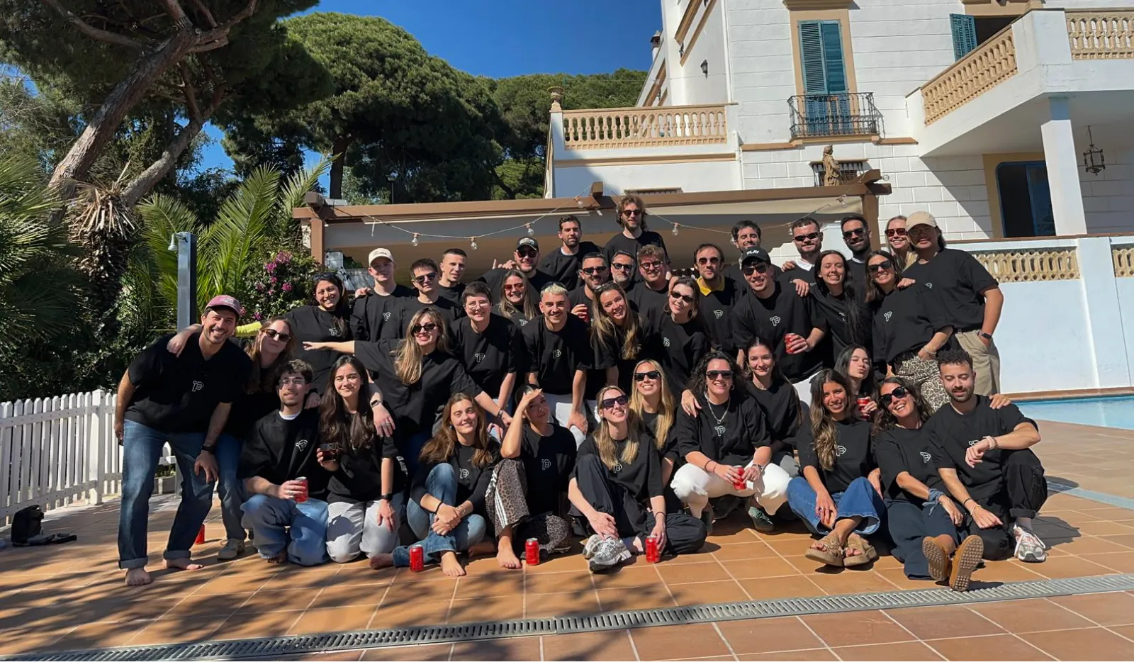 El equipo de PLAY reunido al aire libre, sonriendo durante un encuentro de empresa.