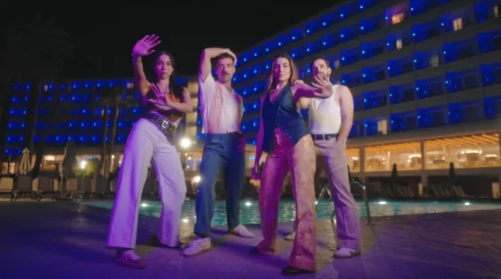 Equipo creativo posando en una azotea durante una producción de marca al atardecer.